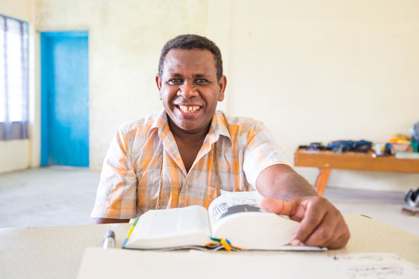 Africa Chad Tomako Cluster Project field coordinator seated with open Bible